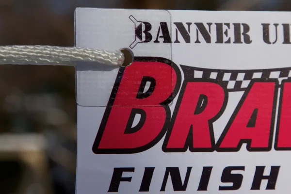 Banner Ups adhesive corner tab holding a banner with rope