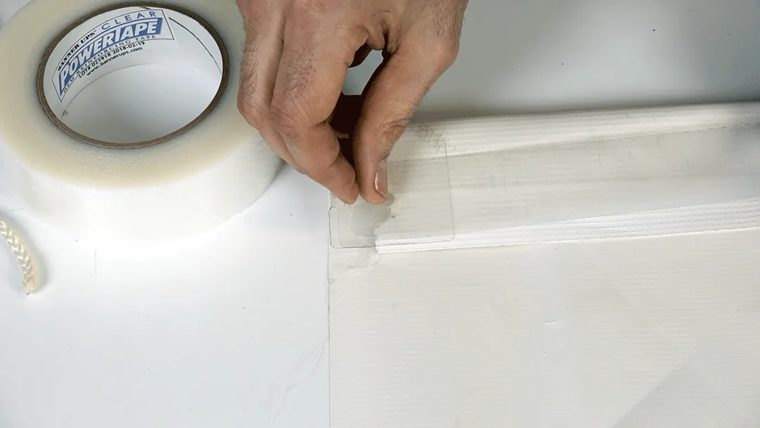Apply Clear PowerTape along the banner edge to reinforce the repair