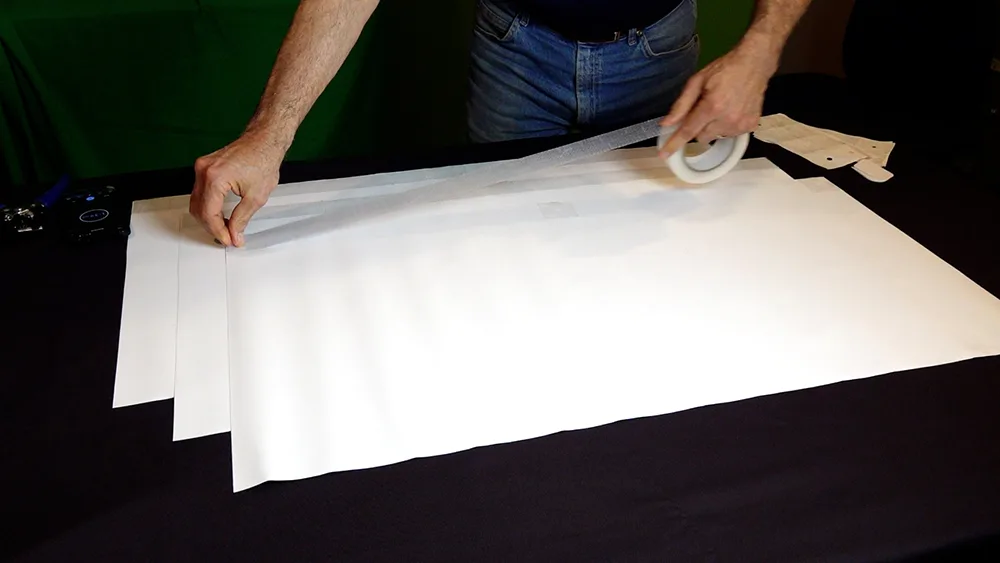 Run Clear PowerTape along the top edge of the stacked banner row